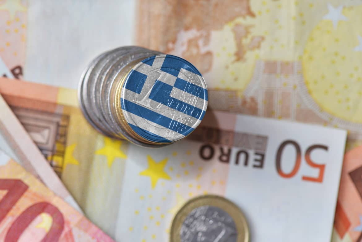 euro coin with national flag of greece on the euro money banknotes background. finance concept