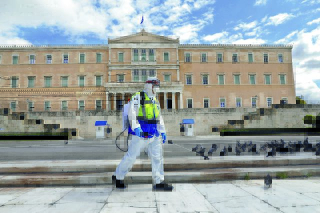 Municipal workers disinfect Syntagma square, in Athens, on March 24, 2020. Greece is on the second day of a strict nationwide lockdown seeking to halt the spread of the COVID-19 infection caused by novel coronavirus, with excursions from the home limited to attending work, buying food, visiting the doctor, walking the dog or going for a solitary jog. / Υπάλληλοι του Δήμου απολυμαίνουν την Πλατεία Συντάγματος κατα την διάρκεια της δεύτερης ημέρας επιβολής απαγόρευσης κυκλοφορίας, με εξαίρεση την έξοδο για και απο το χώρο εργασίας, αγορές τροφίμων, επίσκεψη σε γιατρό και φαρμακείο ή βόλτα κατοικίδιου και προσωπική άσκηση, Αθήνα, 24 Μαρτίου 2020.
