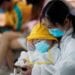 A woman and a child in protective suits check a mobile phone at Wuhan Tianhe International Airport after the lockdown was lifted in Wuhan, the capital of Hubei province and China's epicentre of the novel coronavirus disease (COVID-19) outbreak, April 10, 2020.  REUTERS/Aly Song