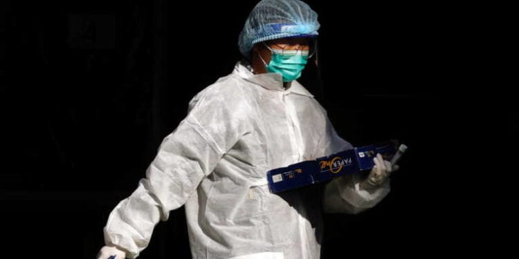 A medical worker in a protective suit walks at a makeshift community testing centre for the coronavirus disease (COVID-19), in Hong Kong, China November 30, 2020. REUTERS/Tyrone Siu