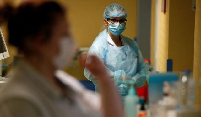 Nurses, wearing protective masks and protective suits, work in a Covid-19 medicine unit where patients suffering from the coronavirus disease (COVID-19) are treated at the Bethune-Beuvry hospital in Beuvry, France, October 16, 2020. REUTERS/Pascal Rossignol