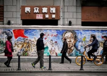 People wearing face masks walk on a street almost a year after the global outbreak of the coronavirus disease (COVID-19) in Wuhan, Hubei province, China December 7, 2020. Picture taken December 7, 2020. REUTERS/Aly Song