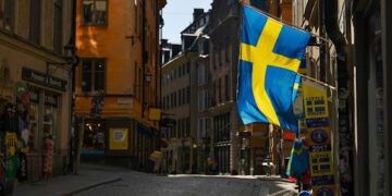 Swedish flags fly from a tourist souvenir shop in Gamla Stan in Stockholm, Sweden, on Thursday, March 26, 2020. Sweden is starting to look like a global outlier in its response to the coronavirus. Photographer: Mikael Sjoberg/Bloomberg